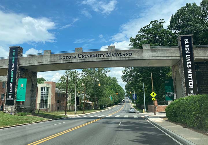 Banners supporting racial justice along Loyola University Maryland's bridge crossing North Charles Street