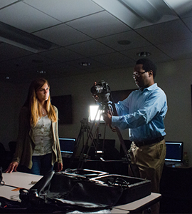 Jay Dunmore, television station manager for GreyComm Studios pictured with a Loyola student