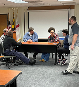 Participants in the LEAD model training program meet at a table to discuss initiatives 