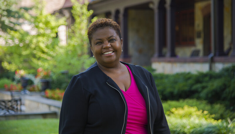 Cheryl Moore-Thomas, Ph.D., NCC, smiling while standing outside in front of the Humanities Center on Loyola's Evergreen campus