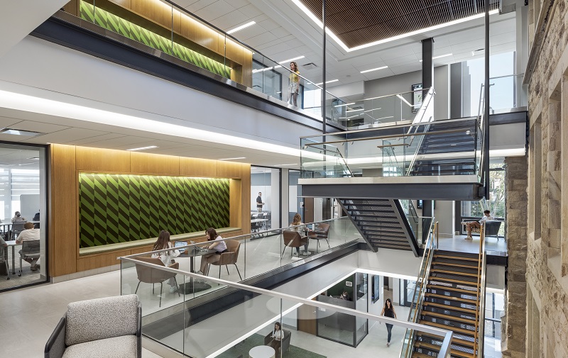 Students sit studying in an open second floor space in the sunlight, contemporary Fernandez Center at Loyola
