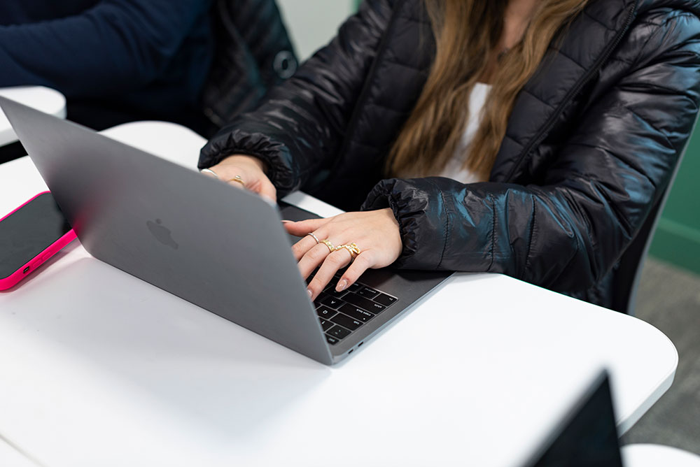 Student typing on laptop.