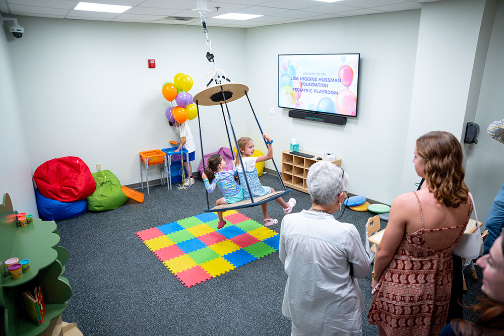 Children play on a swing at the grand opening of the Lisa Higgins Hussman Foundation Pediatric Playroom at the Loyola Clinical Centers on June 4, 2025 (Ryan Hiebler, '26).