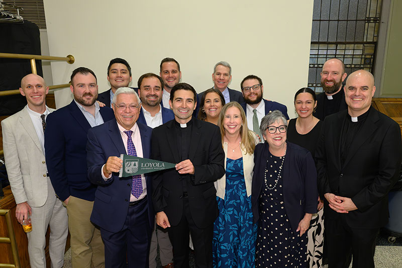 The Rev. Jonathan Pennacchia, S.J., '14, poses with fellow Loyola alumni after his ordination and first Mass.