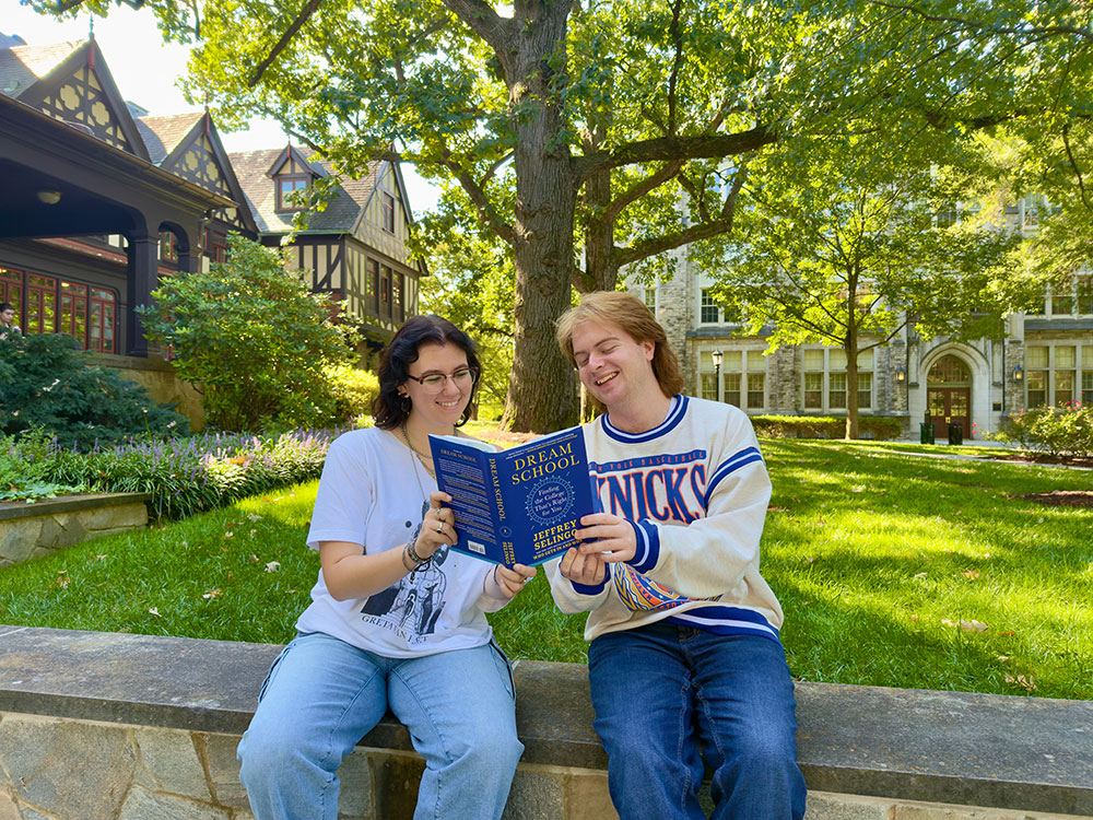 Loyola students reading a copy of Dream School in front of the Humanities Center