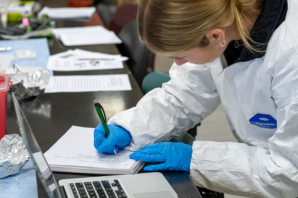 A Loyola forensic science student takes notes in a lab