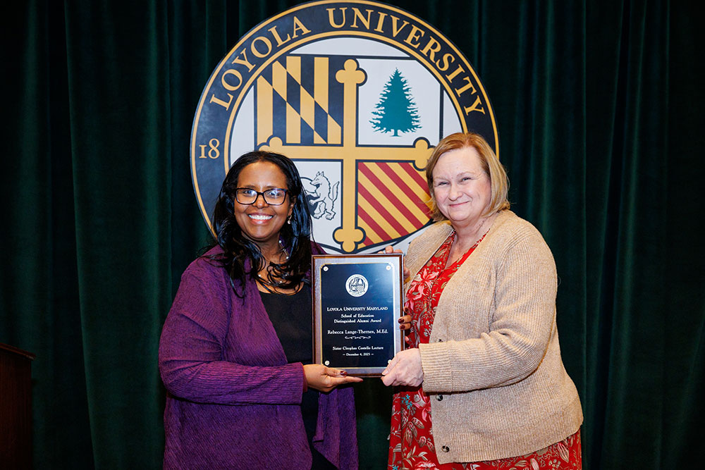 Afra Ahmed Hersi, Ph.D., dean of the School of Education, presents Rebecca Lange-Thernes, M.Ed. ’91, with the University’s School of Education Distinguished Alumni Award on Dec. 4, 2025