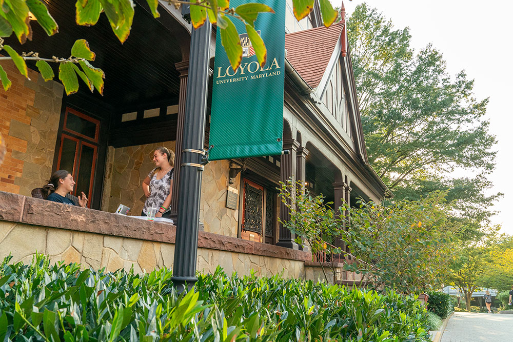 Students on the porch of Loyola University Maryland's Humanities Center