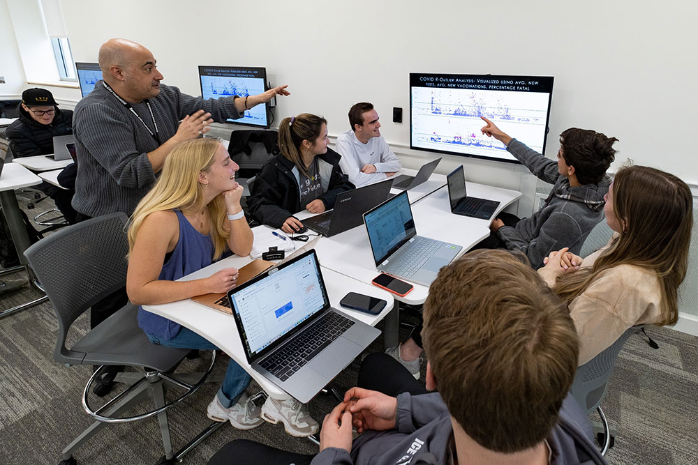 Loyola students looking at computer screens in the data visualization lab