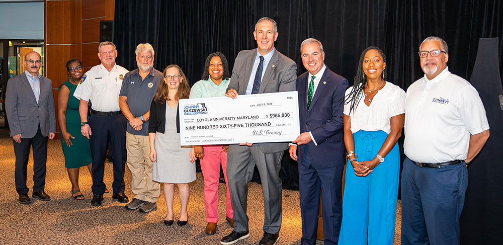 Congressman Olszewski presents President Sawyer with the ceremonial $965,000 check at Newman Towers on Loyola's campus on Thursday, July 9, 2026 (Aaron Boutwell)