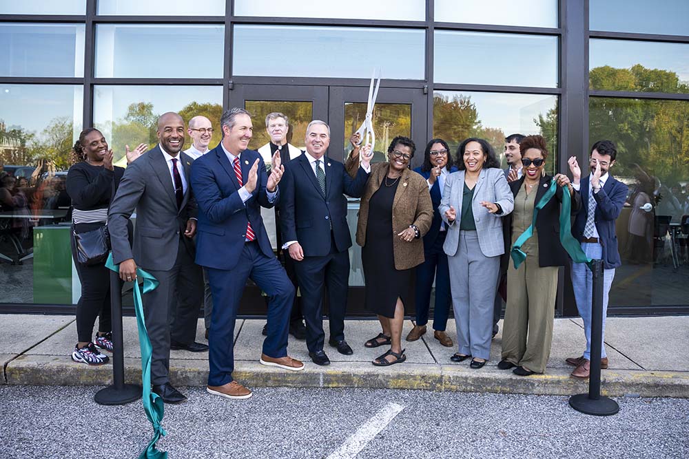 President Terrance Sawyer and community members celebrate ribbon cutting of new community center