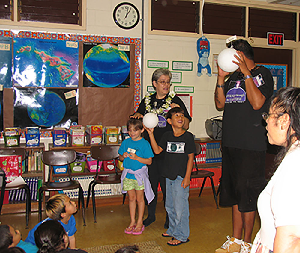 Heyer (middle) conducts a science workshop at a grade school