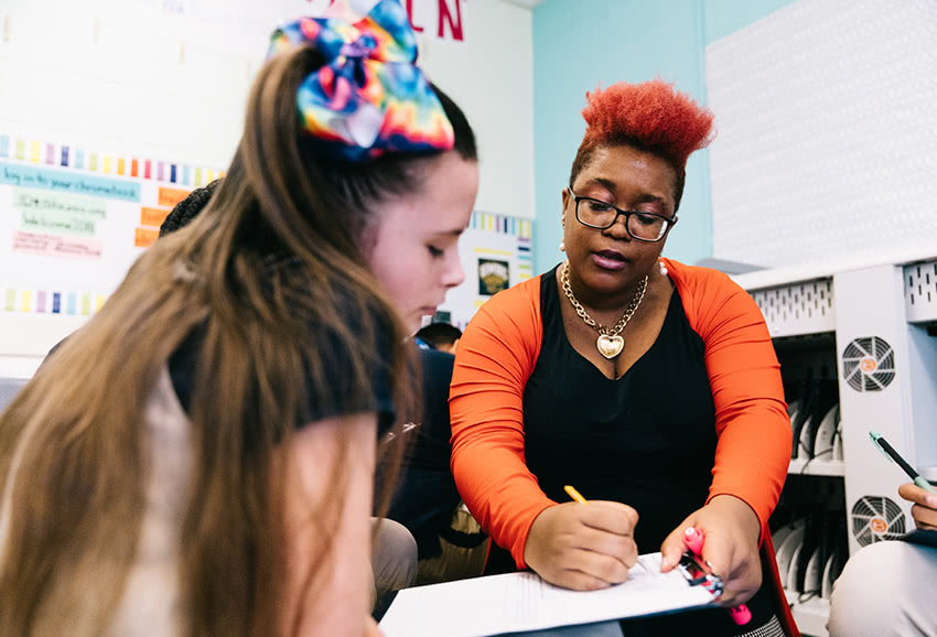 Student and teacher work together on assignment in classroom