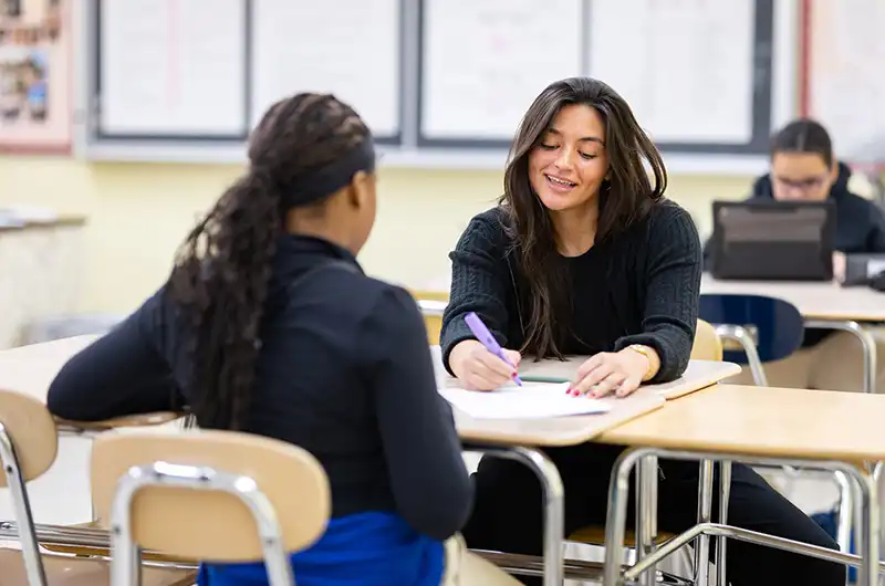 A teacher works with a student on an in class assignment