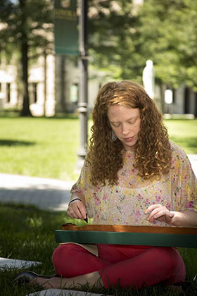 A Loyola student in front of the Jenkins building