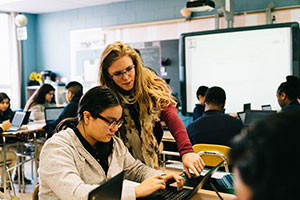 Intern helping student on laptop