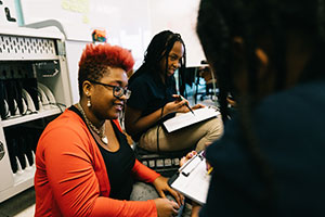 Intern sitting with students in classroom