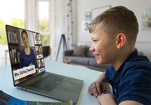 Boy talking to instructor on laptop