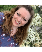 woman with long hair in front of white flowers