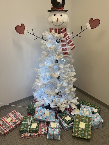 white Christmas tree with snowman head and presents underneath