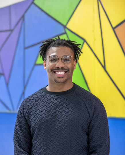 Black man with glasses and a blue sweater