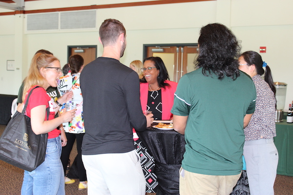 Dean Afra Hersi speking to a group of students and faculty at a party