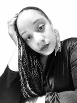  black & white headshot of woman with head tilted, hand on head, and dark braids