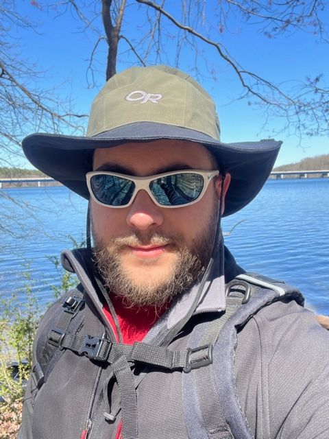 Kevin Solomowitz: man with wide-brimmed hat and sunglasses in front of a body of water