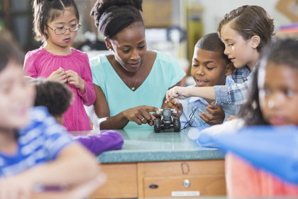 Teacher and students working on remote control car