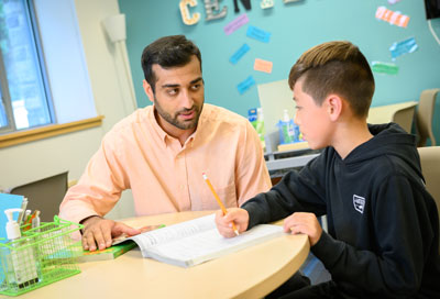 A graduate student in a school working with a young child