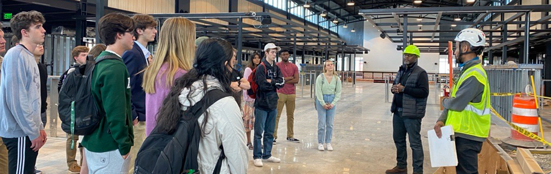 Students tour a modern construction site, engaging with industry professionals to gain real-world insights into project management, safety, and building operations.
