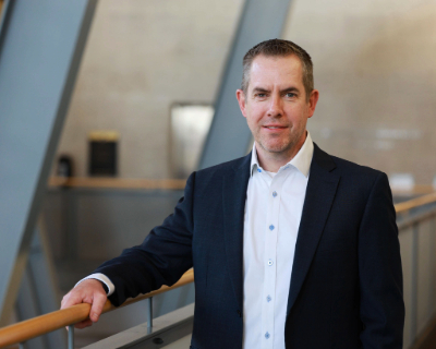 Photo of Professor John Michel standing in the artium of Sellinger Hall
