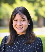 Catherine Liu smiles, wearing a polka dot blouse and pearl earrings