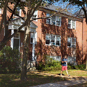 A student walking in front of a residence hall
