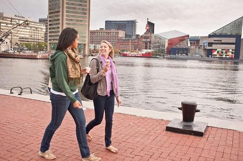 Students eating ice cream while walking alongside the Inner Harbor