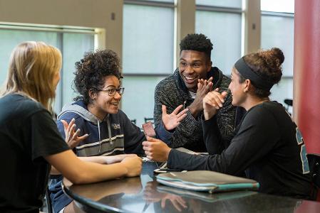 A group of students talking and gesturing emphatically