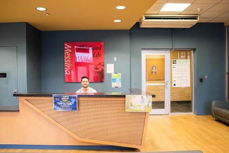 A student smiles at the reception desk of Butler in the lobby