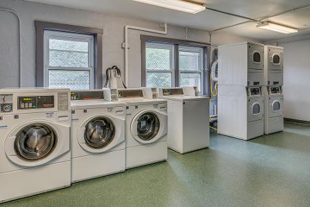 Seton Court laundry room featuring multiple washing machines and multiple dryers