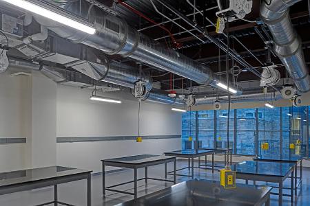A recently renovated general lab for STEM classes at Loyola with clean lines and floor-to-ceiling windows overlooking a stone building.