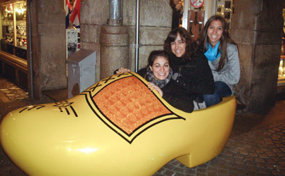 Students pose for a photo inside of an oversized wooden clog shoe