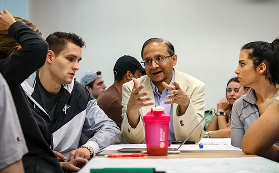 A professor talking with a small group of students