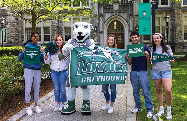 Students and the mascot holding Loyola spirit gear